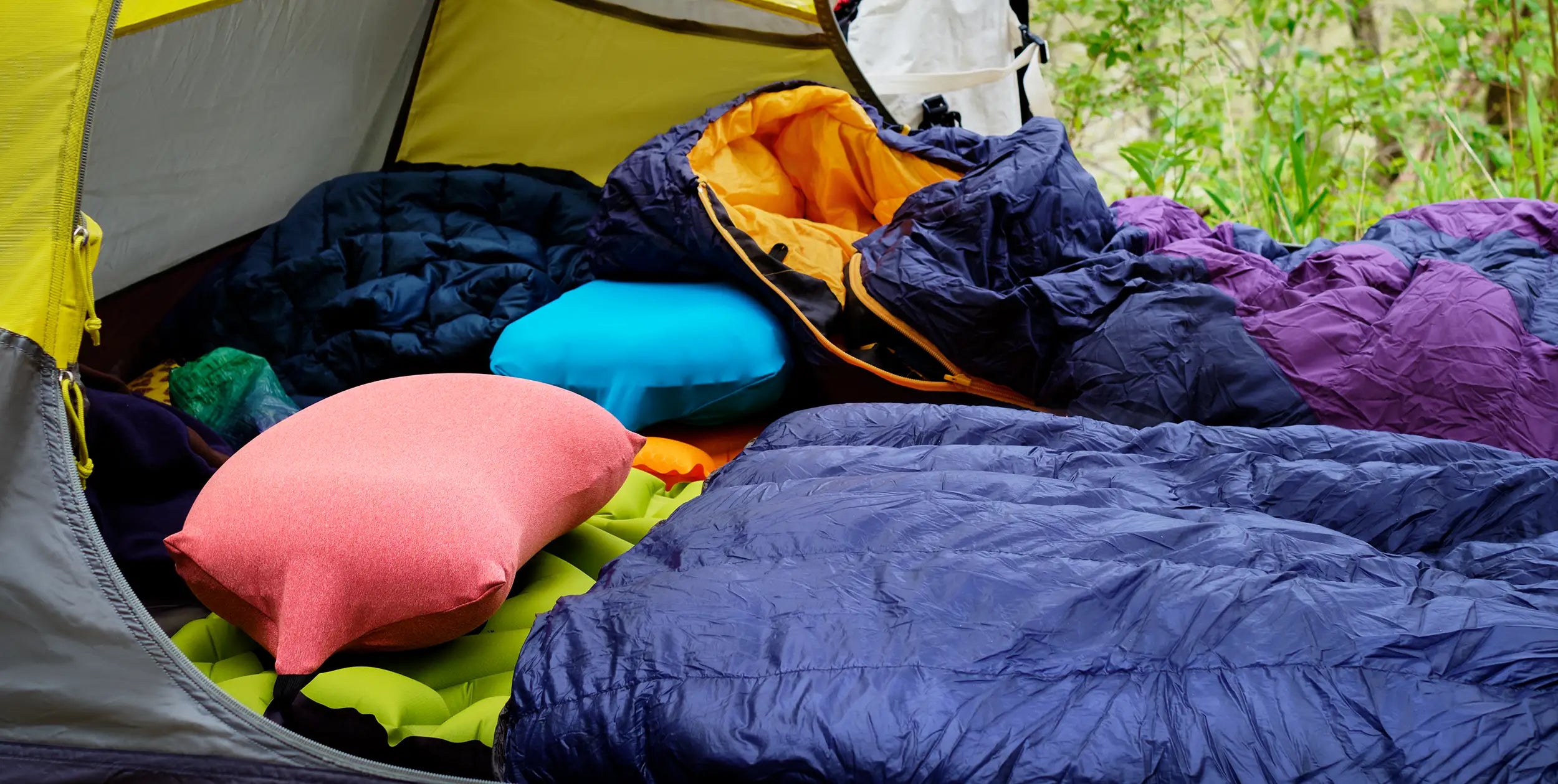 Cozy tent camp with two Pillow Strap camping pillowcases in tent with a sleeping bag and quilt.